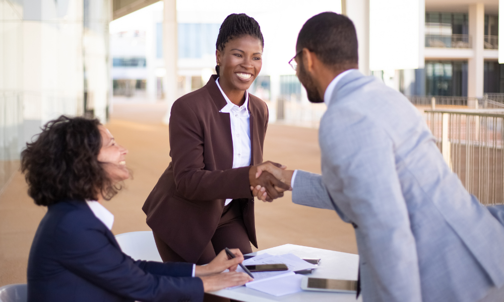 two people shaking hands in a corporate setting