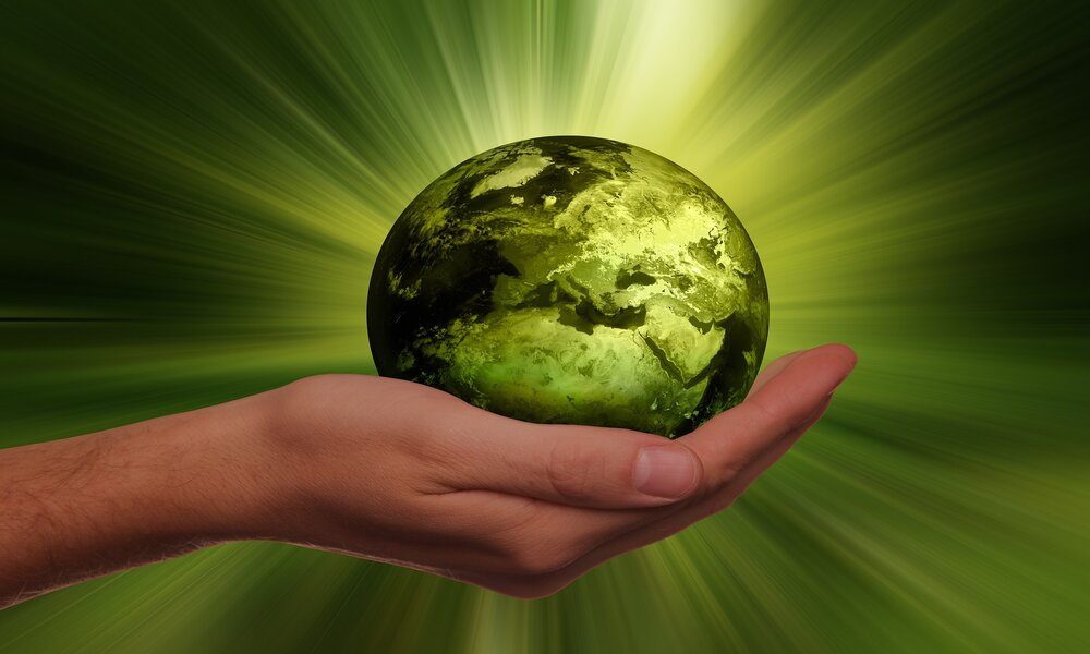 A graphic of a green earth being held in a hand, to symbolise sustainability in the automotive sector